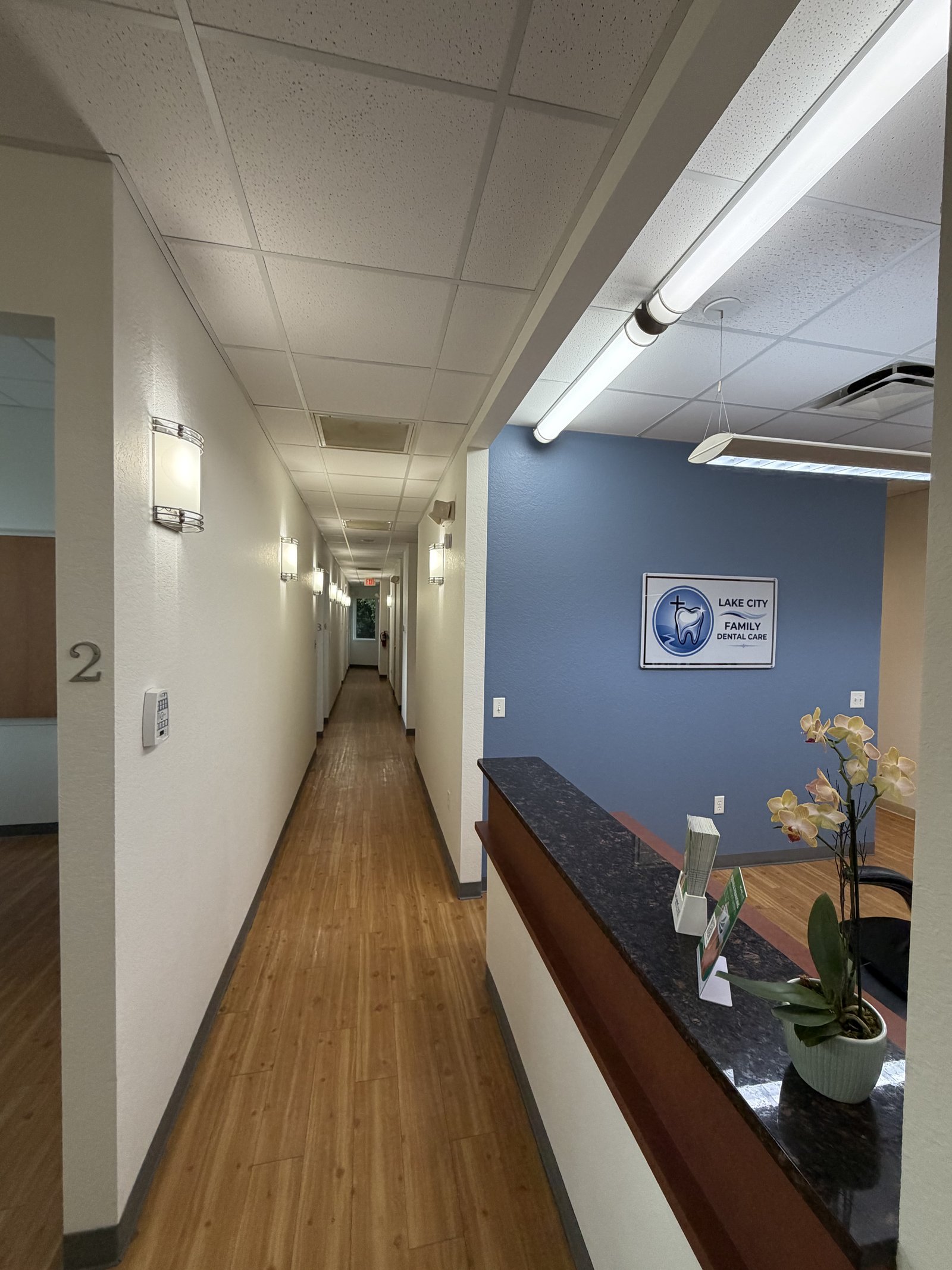 Bright treatment hallway leading past the desk